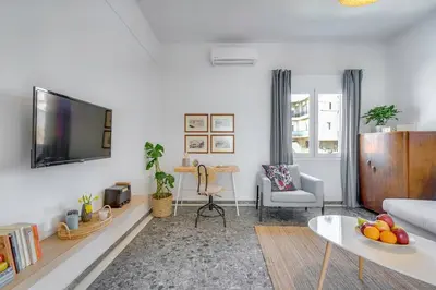 a living room with a couch and a tv on a wall at Sea City and Mountain View Apartment in Chania Town