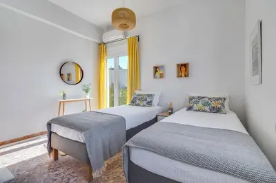 a bedroom with two beds and a window at Sea City and Mountain View Apartment in Chania Town