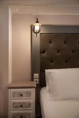 a bedroom with a bed with a headboard and a nightstand at Old Town Suites in Chania Town