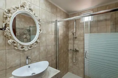 a bathroom with a shower and a sink and a mirror at Old Town Suites in Chania Town