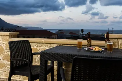 a table with a plate of food and two glasses of beer at Castello Villa - Seaview Villa atop the Venetian Walls in Kissamos