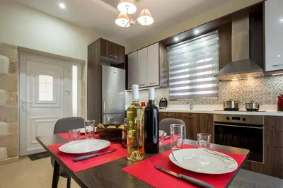a kitchen with a table with wine bottles and glasses at Castello Villa - Seaview Villa atop the Venetian Walls in Kissamos