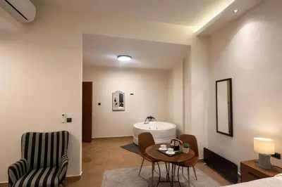 a bathroom with a sink and a table and a chair at Endless Blue Suites in Chania Town