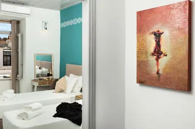 a room with two beds and a painting on the wall at Vista del Puerto in Chania Town