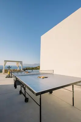 a ping pong table in front of a white wall at Ellas Residence fantastic pool heated in Kissamos
