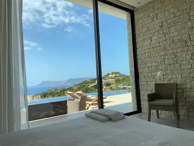 a bedroom with a large window with a view of the ocean at Ellas Residence fantastic pool heated in Kissamos
