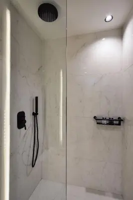 a shower with a glass door in a bathroom at Neorion Living in Chania Town
