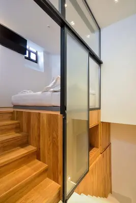 a room with glass walls and stairs with a bed at Neorion Living in Chania Town