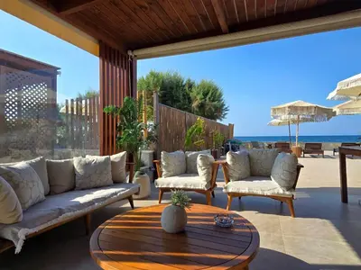 a patio with a couch and chairs and a table at Seastar seafront villa in Kalamaki Chanion