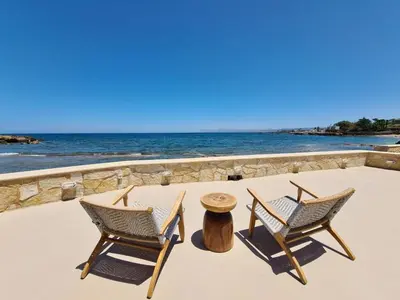 two chairs and a table on the beach at Seastar seafront villa in Kalamaki Chanion
