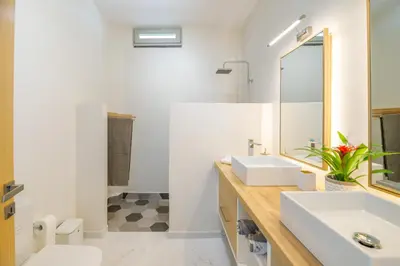 a bathroom with two sinks and a mirror at Villa Evrithea in Kalleryianá