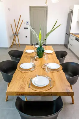 a wooden table with plates and wine glasses on it at Villa Evrithea in Kalleryianá