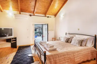 a bedroom with a large bed and a television at Traditional Stone House Rafael in Tzitzifés