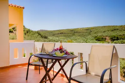 a table with a bowl of fruit on a balcony at Olive Farm in Agia Marina Nea Kydonias
