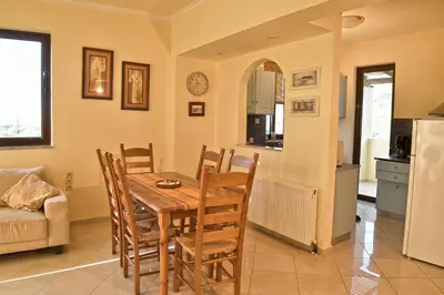 a kitchen and dining room with a table and chairs at Olive Farm in Agia Marina Nea Kydonias