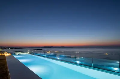 a swimming pool with a view of the ocean at night at SanSal Boutique Hotel in Chania Town