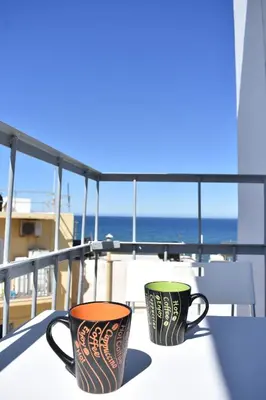 two coffee cups sitting on a table on a balcony at Iris Apartment in Chania Town
