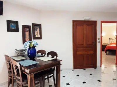 a dining room table with a vase of flowers on it at Villa Eleni Seaside Apartments in Plataniás