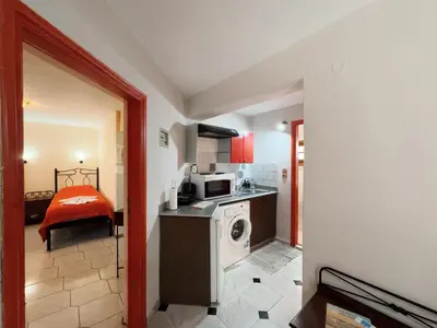 a kitchen with a washer and dryer in a room at Villa Eleni Seaside Apartments in Plataniás