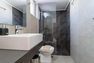 a bathroom with a white sink and a toilet at Helios Residence in Chania Town