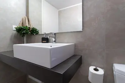 a bathroom with a white sink and a mirror at Helios Residence in Chania Town