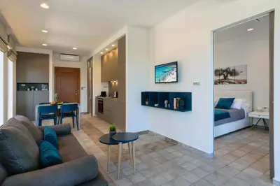 a living room with a couch and a bedroom at Xenios Dias Luxury Apartments With Sea View in Kato Daratso