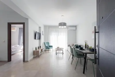 a dining room and living room with a table and chairs at Casa Ntore Luxury Apartments in Chania Town