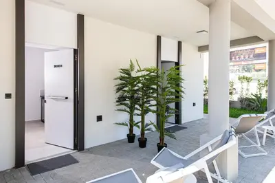 a room with white walls and chairs and plants at Cozy Corner Luxury Apartments in Chania Town