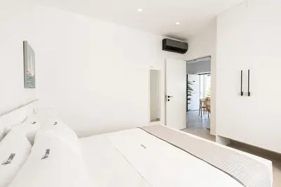 a bedroom with white walls and a large white bed at Cozy Corner Luxury Apartments in Chania Town