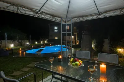 a table with candles and a bowl of fruit on it at Ifigeneia's Lavish Escape with Private Hot Tub in Kalathas