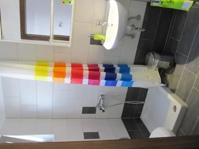 a bathroom with a rainbowicolored towel on a bath tub at Lion-Suites in Kalyves
