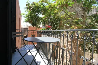 a table on a balcony with a fence at Fagotto Art Residences in Chania Town
