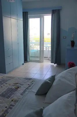 a bedroom with a bed and a sliding glass door at Mastorakis Village in Agia Marina Nea Kydonias