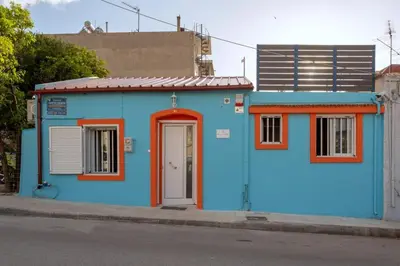 a blue building with a red door on a street at Casa di Mona in Chania Town