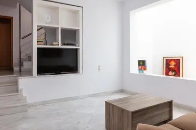 a living room with a tv and a couch and a table at Angels Villa - 8-Bedroom Estate Ideal for Groups & Families by etouri in Kambánion