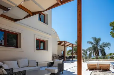an outdoor patio with a couch and chairs and a table at Angels Villa - 8-Bedroom Estate Ideal for Groups & Families by etouri in Kambánion
