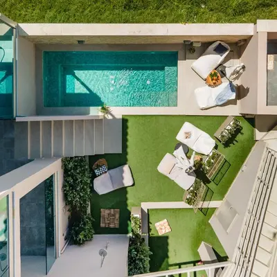 an aerial view of a house with a swimming pool at Aegean Breeze Luxury Apartments next to the sea in Maleme