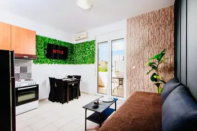 a living room with a couch and a kitchen with a table at Pearl Seaside Cozy Apartments in Chania Town