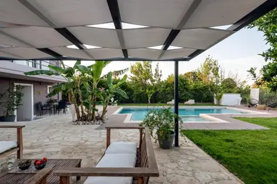a patio with a white umbrella and a swimming pool at Elenas Village house - Dream apt w Pool & Terrace in Alikianós