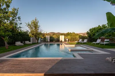 a swimming pool in a yard with chairs and trees at Elenas Village house - Dream apt w Pool & Terrace in Alikianós