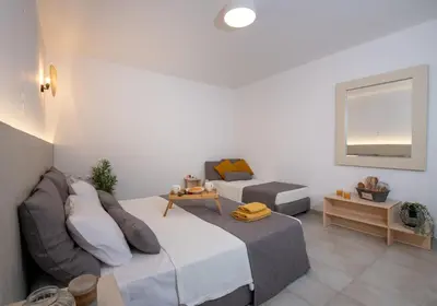 a bedroom with a bed and a couch and a table at Elenas Village House - Love apartment with Pool and Terrace in Alikianós