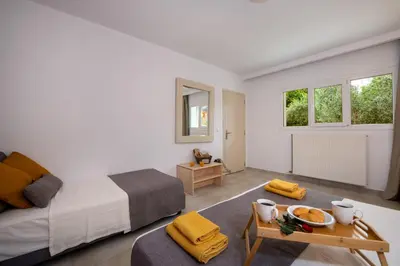 a white bedroom with a bed and a table at Elenas Village House - Love apartment with Pool and Terrace in Alikianós