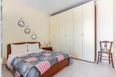 a bedroom with a bed and a chair at Wonderful Villa in Chania with Private Pool, Panoramic Sea Views & Spacious Interiors in Agios Onoufrios