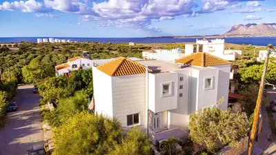 an aerial view of a white house with the ocean in the background at Wonderful Villa in Chania with Private Pool, Panoramic Sea Views & Spacious Interiors in Agios Onoufrios