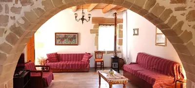 a living room with two red couches and a table at Irene's Guest House in Frés