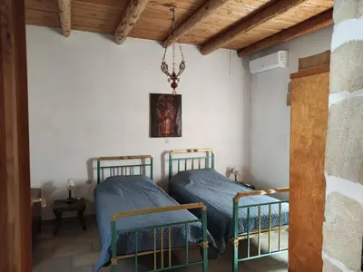 two twin beds in a room with wooden ceilings at Irene's Guest House in Frés