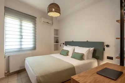 a bedroom with a bed with a table and a window at Soleado Studio in Chania Town