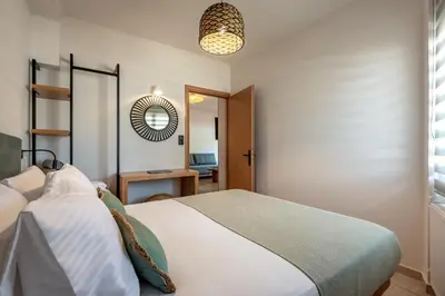 a bedroom with a bed and a mirror at Soleado Studio in Chania Town