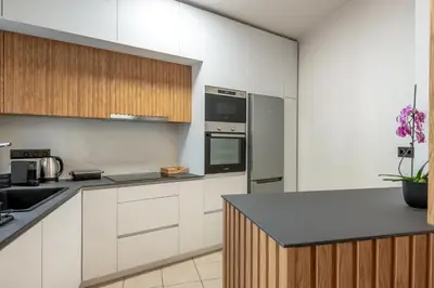a kitchen with white cabinets and stainless steel appliances at Soleado Studio in Chania Town