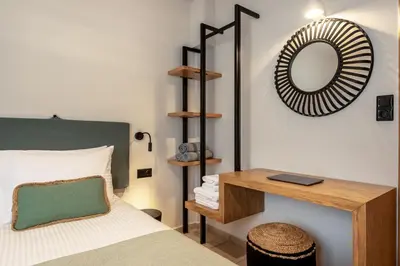 a bedroom with a bed and a mirror and a table at Soleado Studio in Chania Town
